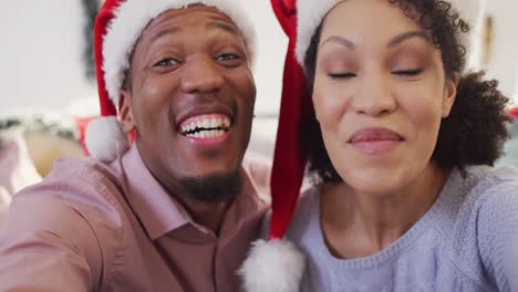 Porträt-Eines-Glücklichen-Afroamerikanischen-Paares-Mit-Weihnachtsmützen,-Das-Einen-Videoanruf-Führt