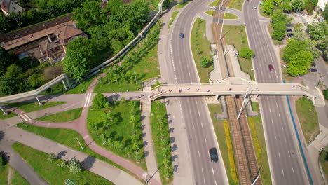 flying a drone over a busy street and passing people over the route of several lanes of cars driving below