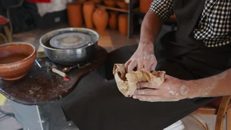 ceramist packing his handmade clay product into paper