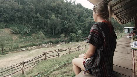 female tourist looking out over jungle valley in an elephant sanctuary