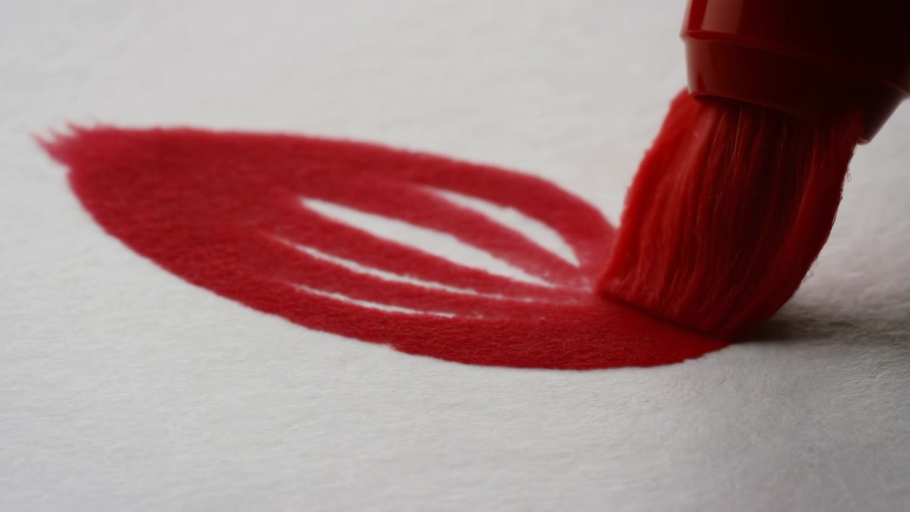Makro pohled z nízkého úhlu ukazuje špičku štětcového fixu vtlačující hustý karmínový pigment do texturovaného krémově bílého papíru, vytvářející půlměsíční vzorek se třemi úzkými negativními pruhy a jemnými detaily stínu.