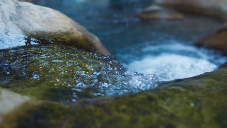 clear stream running through stone boulders