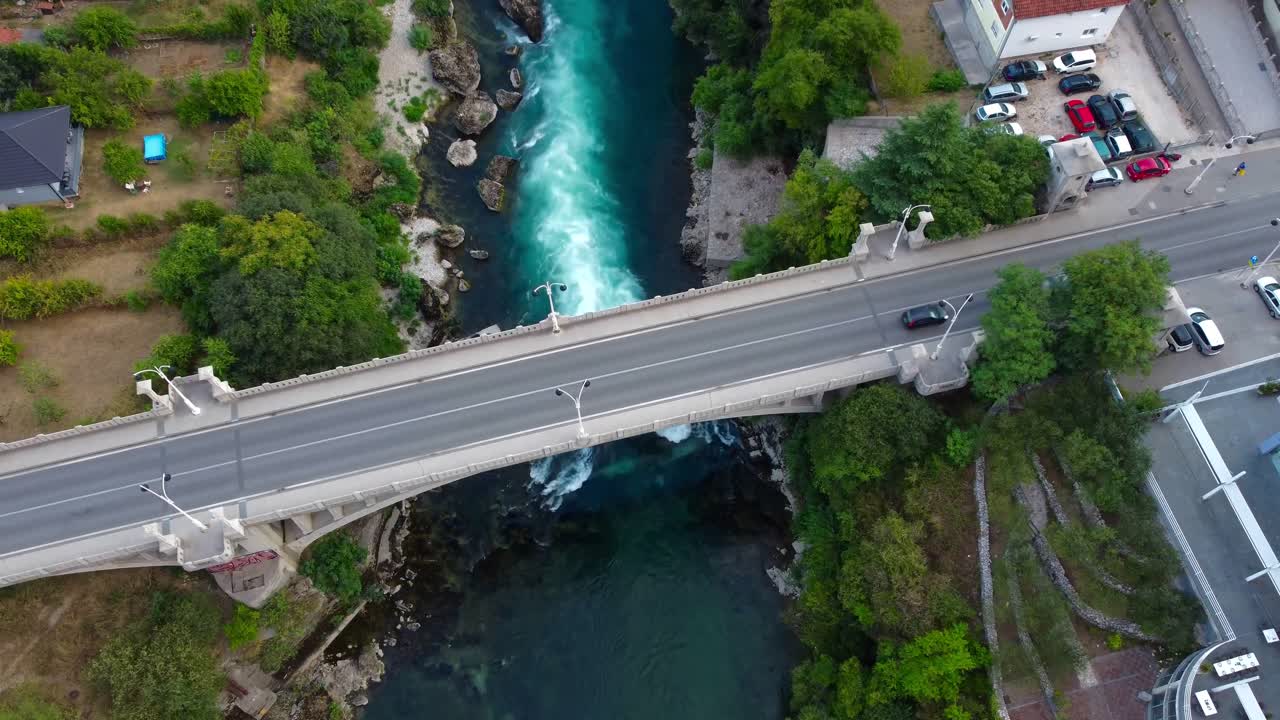 Drone 4K video of cars driving on bridge above river - Neretva River, Mostar, Bosnia and Herzegovina