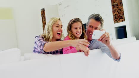 Happy-family-taking-selfie-on-mobile-phone-in-living-room-4k