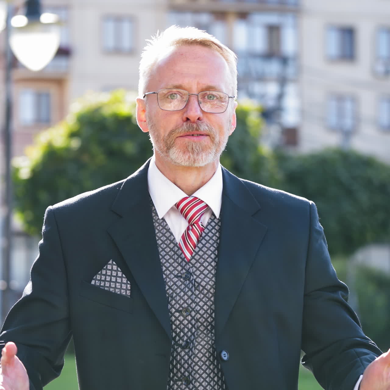Mature businessman talking on the mobile phone outdoors. Successful elderly business man finishes talking on the phone and shows yes gesture by his hands.