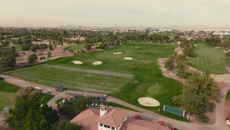 push in aerial drone shot of a golf course driving range