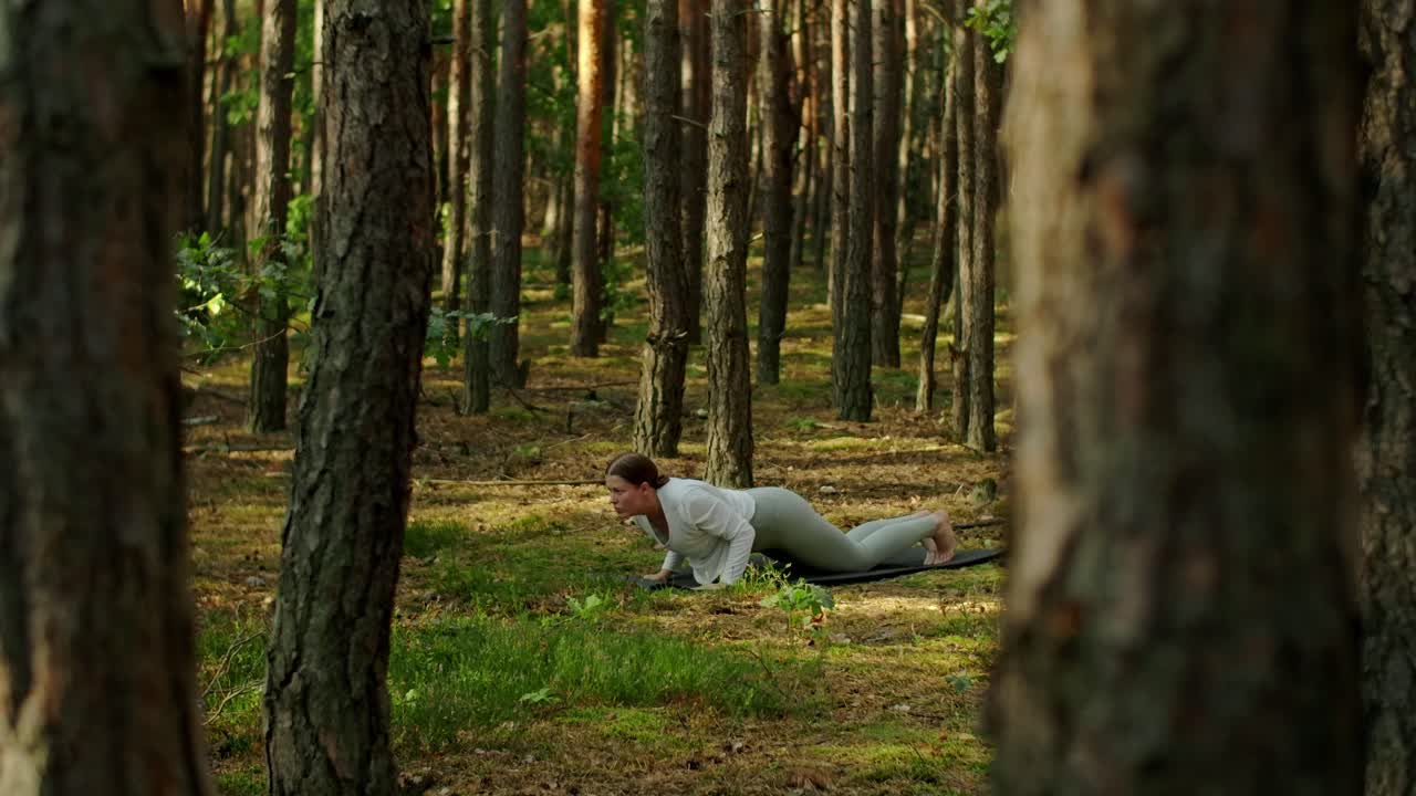 Donna che pratica yoga nella foresta