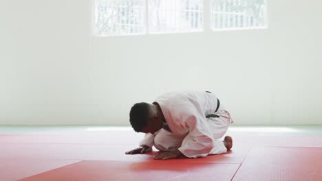 kneeling judoka saluting on the judo mat