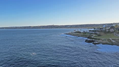 Schwenkdrohnenaufnahme-Mit-Horizontlinie-Und-Spur-Mit-Wellen,-Die-Während-Der-Königsflut-Auf-Klippen-In-La-Jolla,-Kalifornien,-Krachen