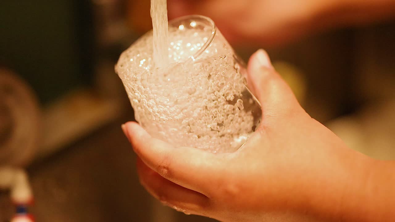 흐르는 물 에서 유리를 들고 있는 손