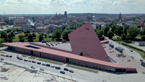 Luftdrohnenaufnahme-Von-Autos,-Die-Im-Sommer-Auf-Der-Straße-Neben-Dem-Modernen-Museum-Des-Zweiten-Weltkriegs-Fahren