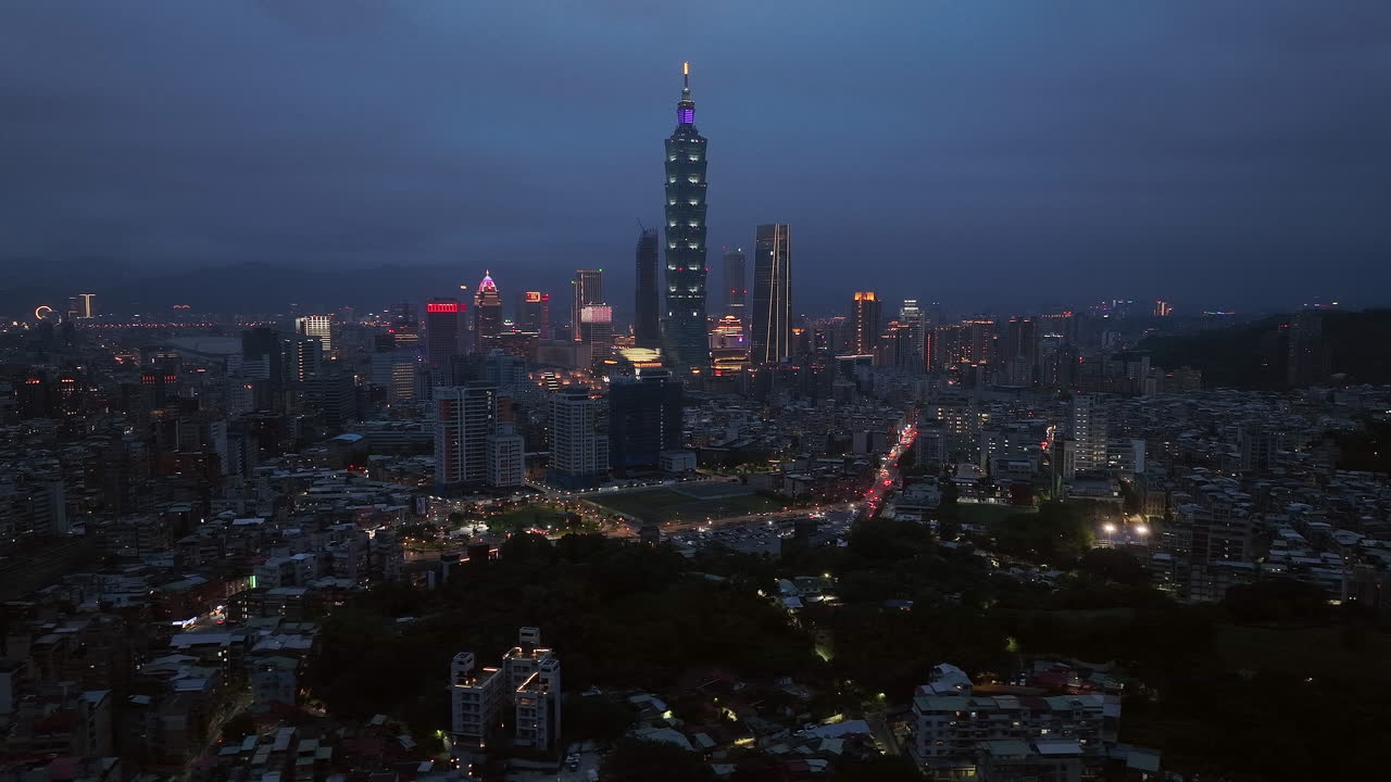 Aerial trucking shot of tower 101 and skyline of Taipei Coty at night