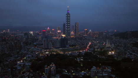 aerial trucking shot of tower 101 and skyline of taipei coty at night