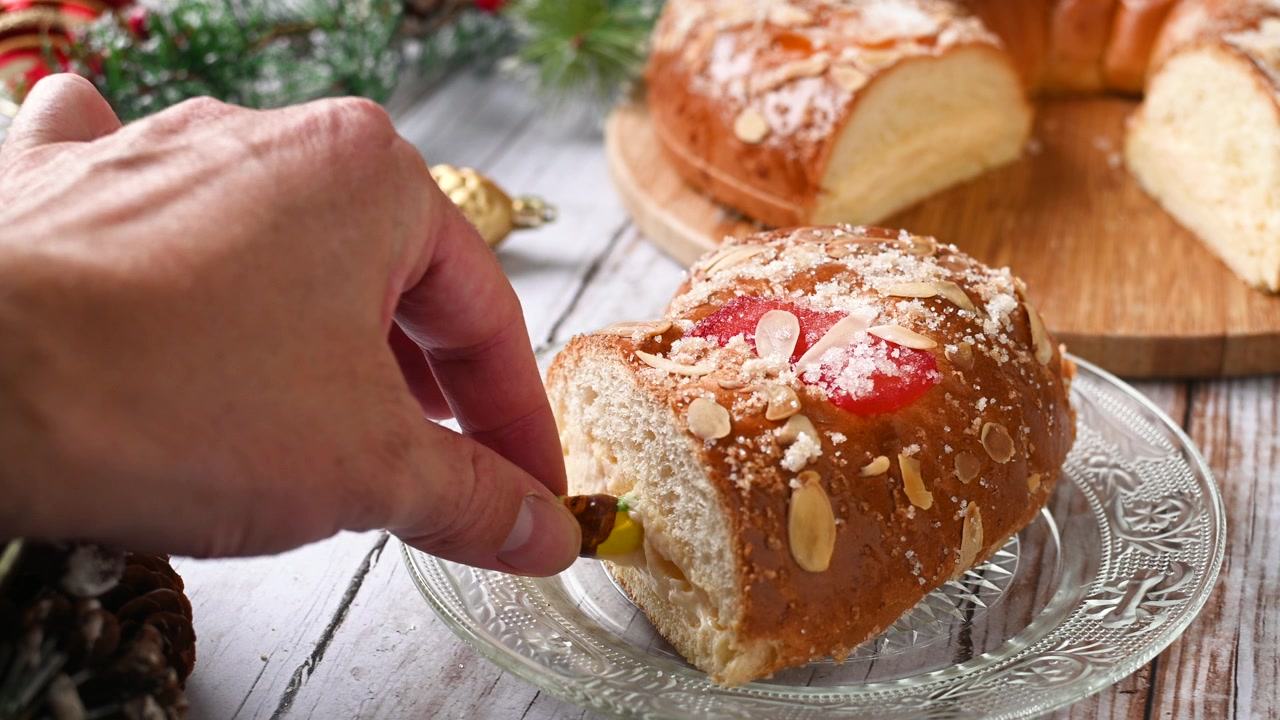 Man's hand removing the king from the Epiphany cake or Roscón de Reyes