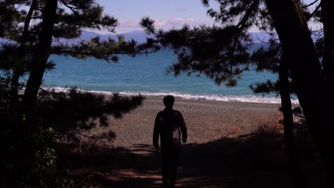 Silhouette-Eines-Mannes,-Der-Tagsüber-In-Richtung-Öffnung-Am-Strand-Geht