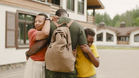 back view of an military father his wife and son outside home