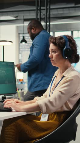 vertical video office administrator uses focus music on headset to solve tasks