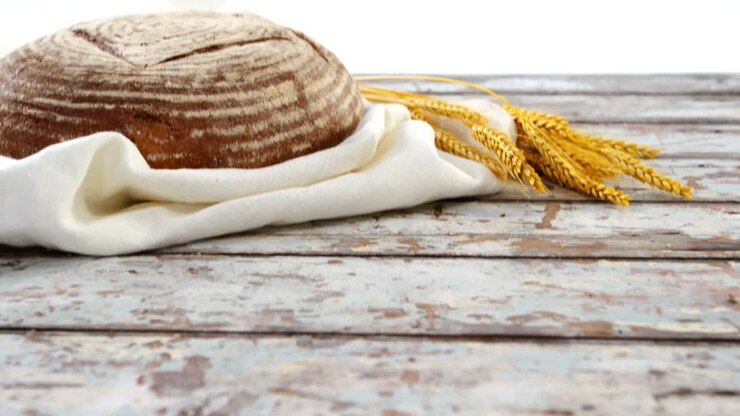Sourdough with wheat grains on wooden table
