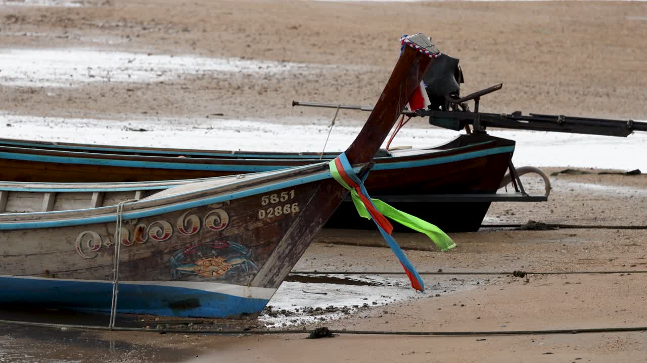 un barco tradicional tailandés de cola larga descansa en una playa de arena de phuket, mostrando colores vibrantes y diseños intrincados