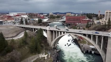 cars driving at the monroe street bridge across spokane river in washington on a cloudy day - aerial, slow motion