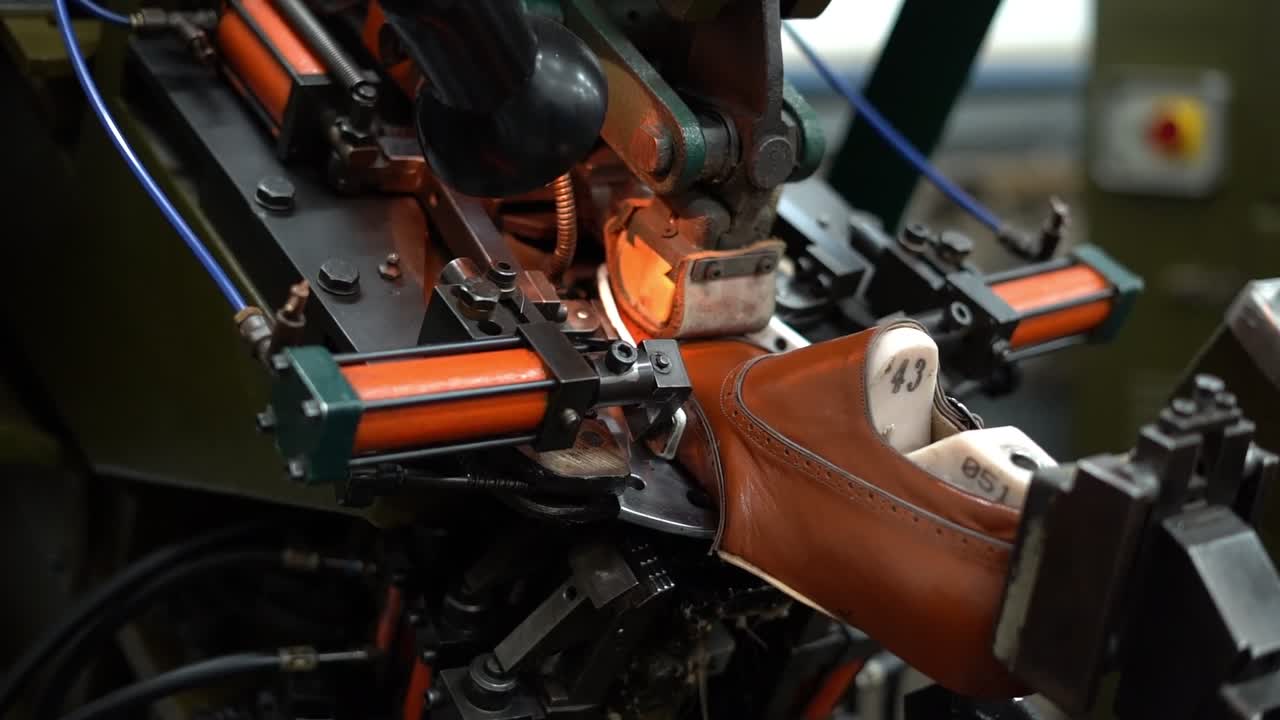 a craftsman handmade a shoe by a machine, close up shot, insert shot