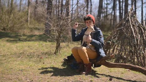 young female with short hair plays with her dog in the country using a stick 1