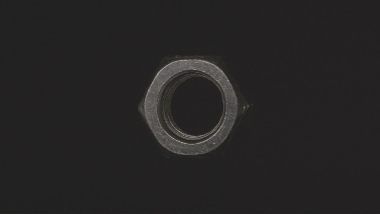 metal nut spinning in the void on a black background