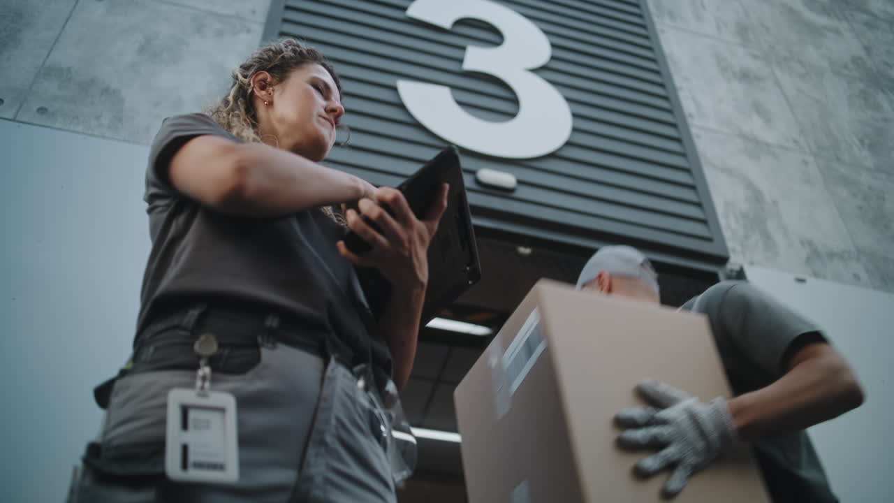 Warehouse Workers Managing Logistics and Deliveries with a Tablet