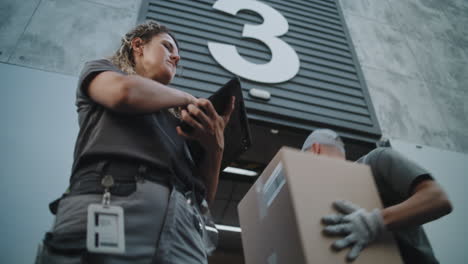 warehouse workers managing logistics and deliveries with a tablet