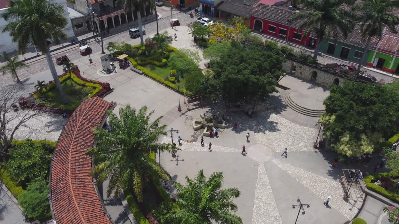 la gente camina en la plaza circular del pequeño parque central en copán, honduras.