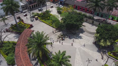 People-walk-in-circular-plaza-of-small-Central-Park-in-Copan,-Honduras