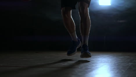 jugador de baloncesto dribbling primer plano en una habitación oscura en el humo primer plano en cámara lenta