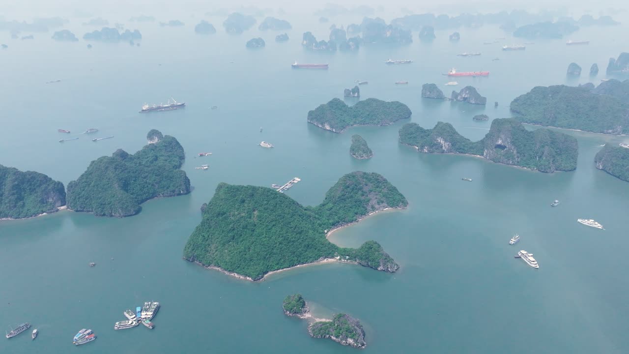 Ha long bay islands with boats on calm blue water, peaceful atmosphere, aerial view