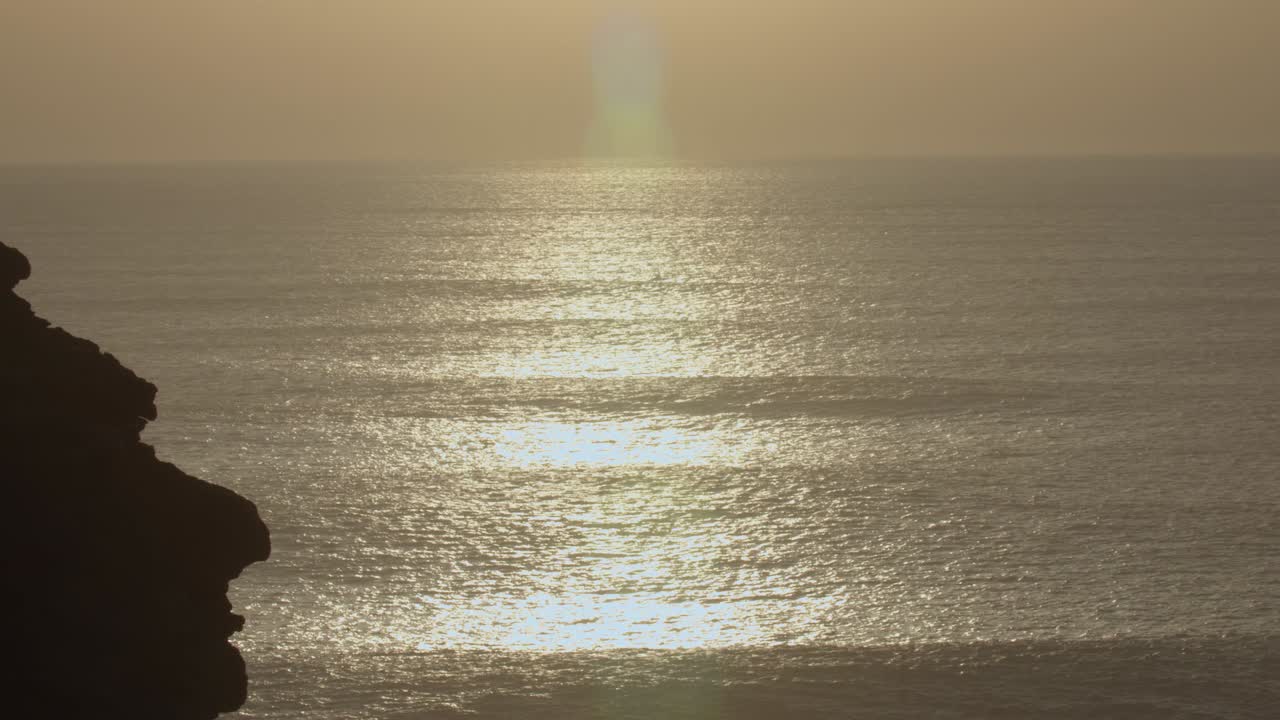 reflejos de la puesta de sol sobre el agua en la playa norte de nazaré en portugal