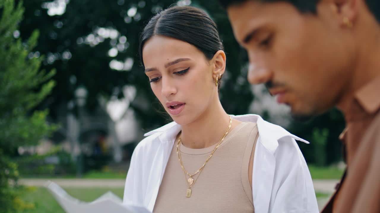 자연에서 종이를 작업하는 클로즈업 여성 수직 뷰. 문서를 분석하는 커플