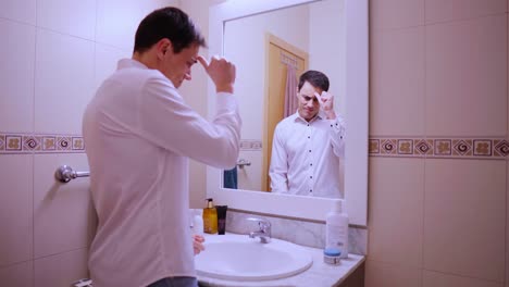 Nervous businessman rehearsing speech in bathroom mirror