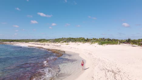 Disparo-De-Gran-Angular-De-Una-Hermosa-Joven-Caucásica-Caminando-Por-Las-Playas-De-Arena-Blanca-En-La-Isla-Tropical-De-Cozumel-En-México-Durante-Un-Caluroso-Día-Soleado-En-4k