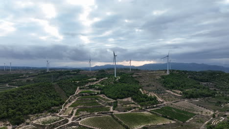 dramatic landscape and clouds with wind turbines not moving on the horizon