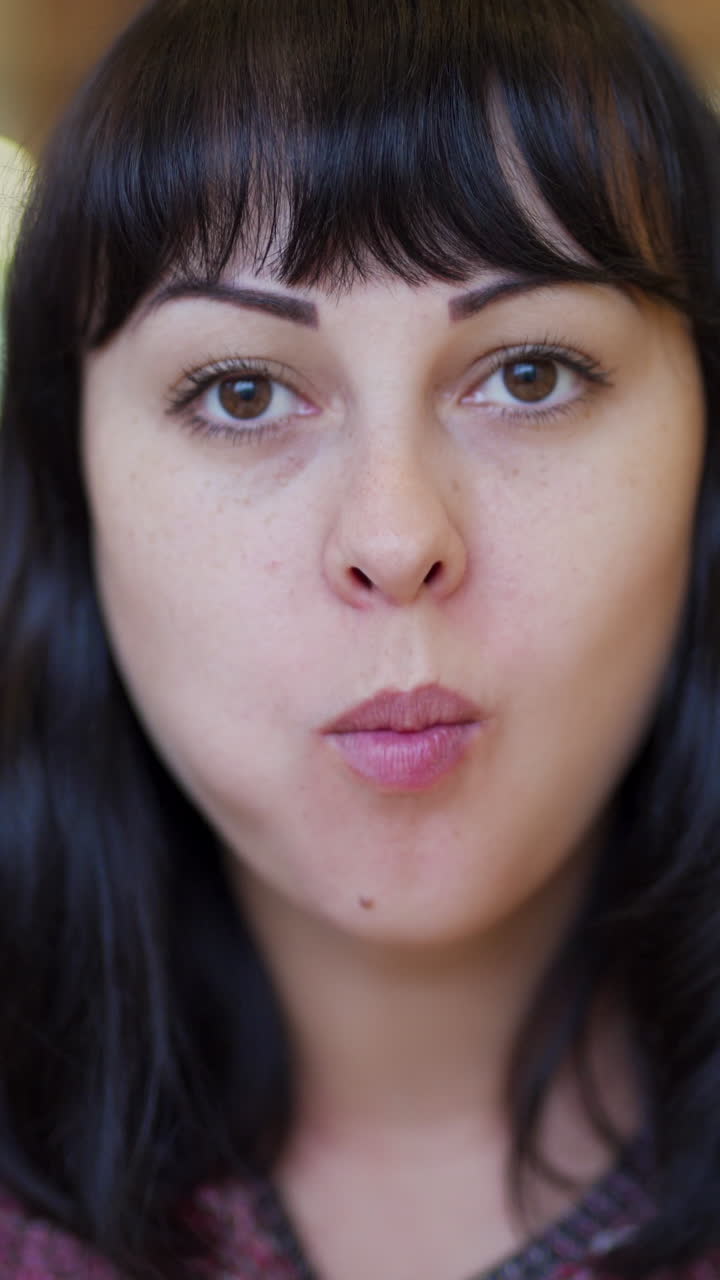 hungry young woman eating a big hamburger in a fast food restaurant Vertical video