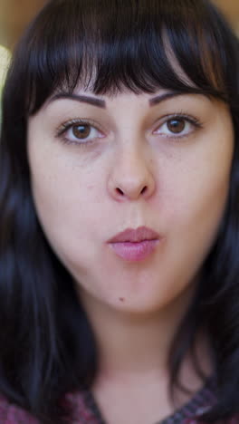 hungry young woman eating a big hamburger in a fast food restaurant vertical video