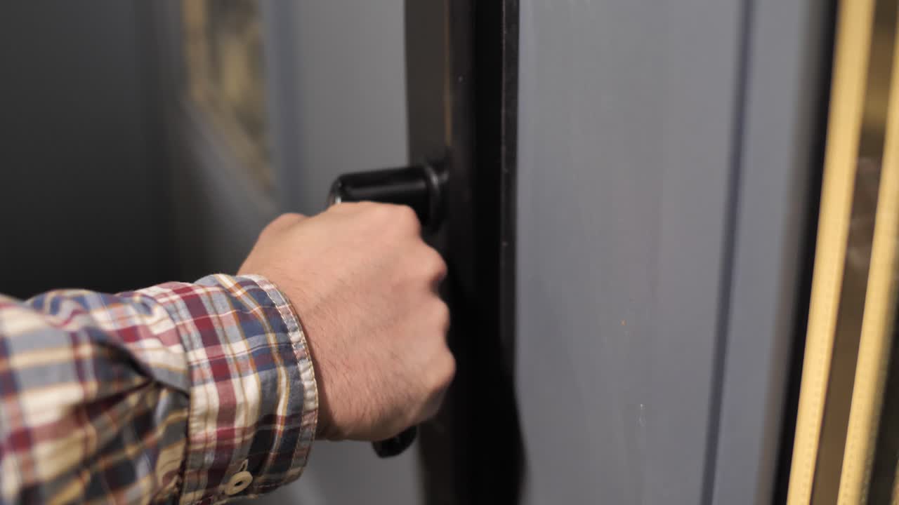 조심스럽게 문을 여는 의심스러운 남성의 손에 가까이