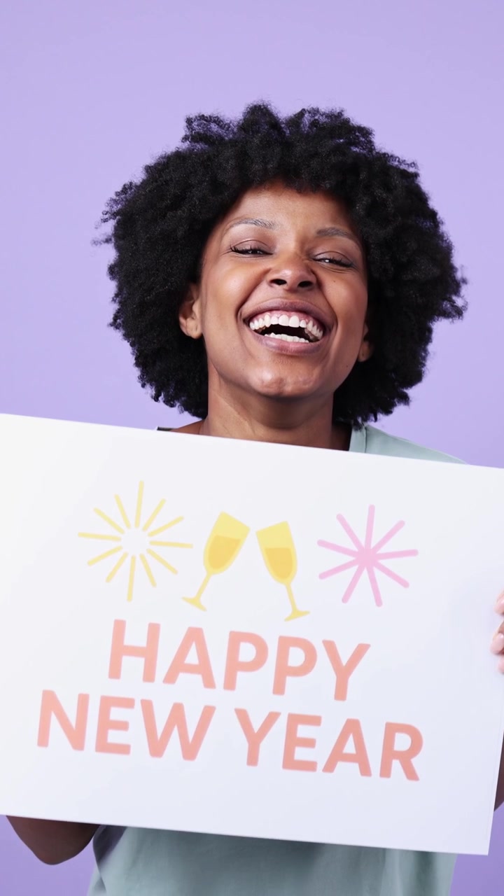 Donna afroamericana gioiosa che tiene un cartello 'Felice Anno Nuovo' su sfondo viola