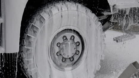 large truck tire being washed with soap foam