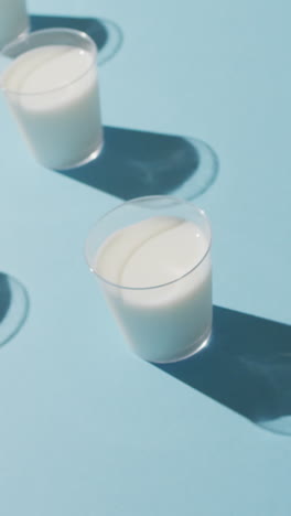 video de una fila de vasos de leche sobre un fondo azul
