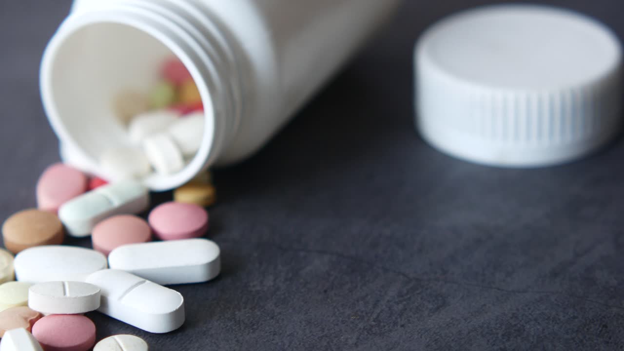 색 병에서 흘러내리는 약의 근접 사진