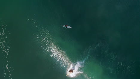 Slow-Motion:-Aerial-cenital-cinematic-shot-of-a-surfer-surfing-a-big-tube-barrel-wave-that-creates-a-rainbow-in-Zicatela-beach-Puerto-Escondido,-Oaxaca