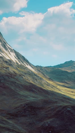 Majestic mountain landscape under bright blue skies with soft clouds