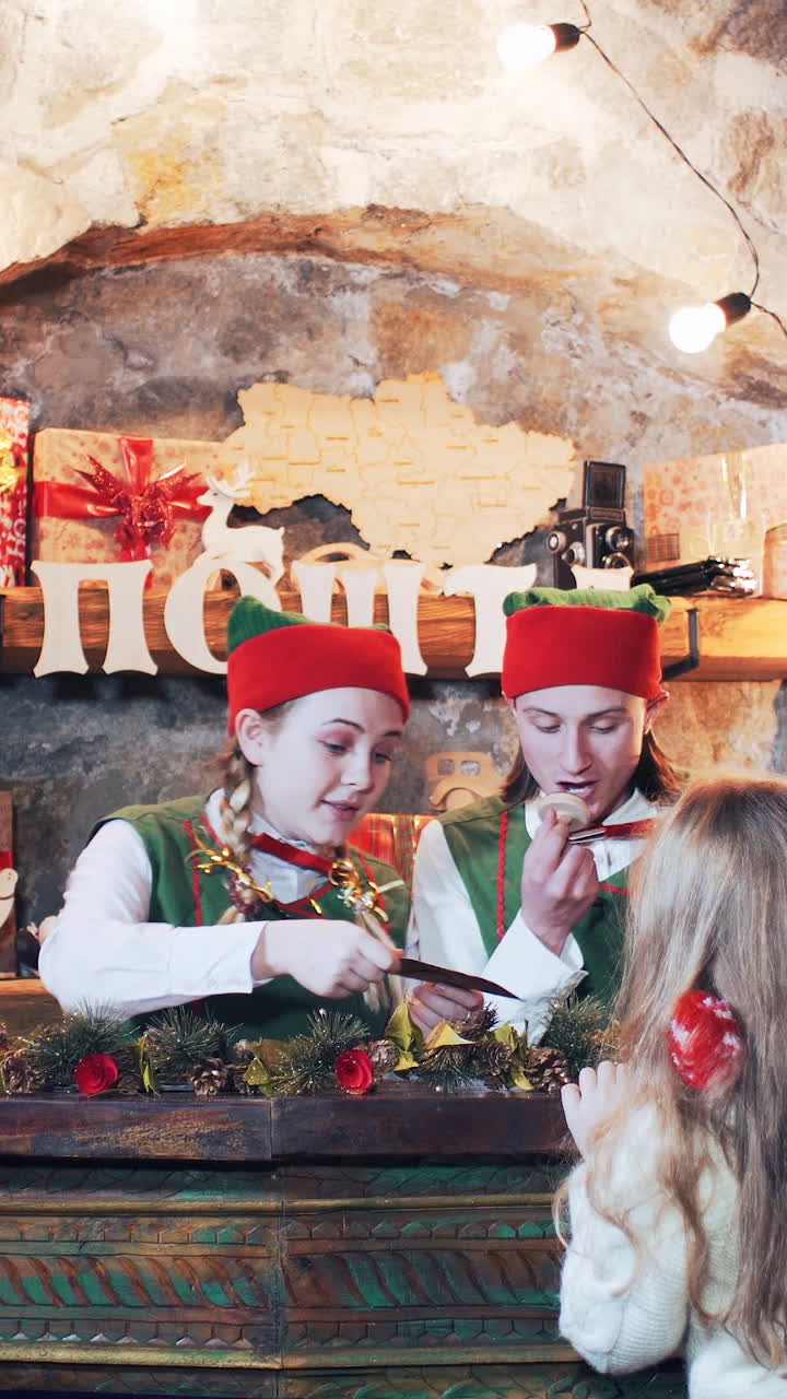 children and elves send a letter to santa claus at the christmas residence. Vertical video