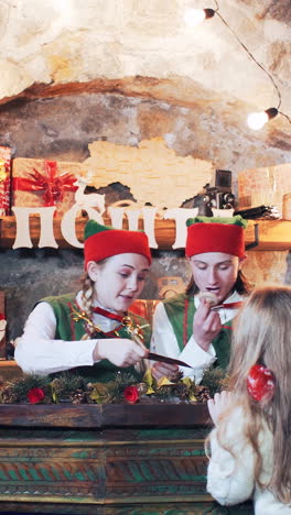 children and elves send a letter to santa claus at the christmas residence. vertical video