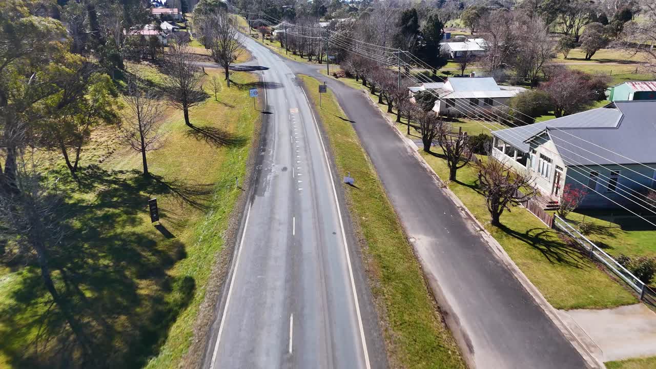 Small town street lined with houses and greenery